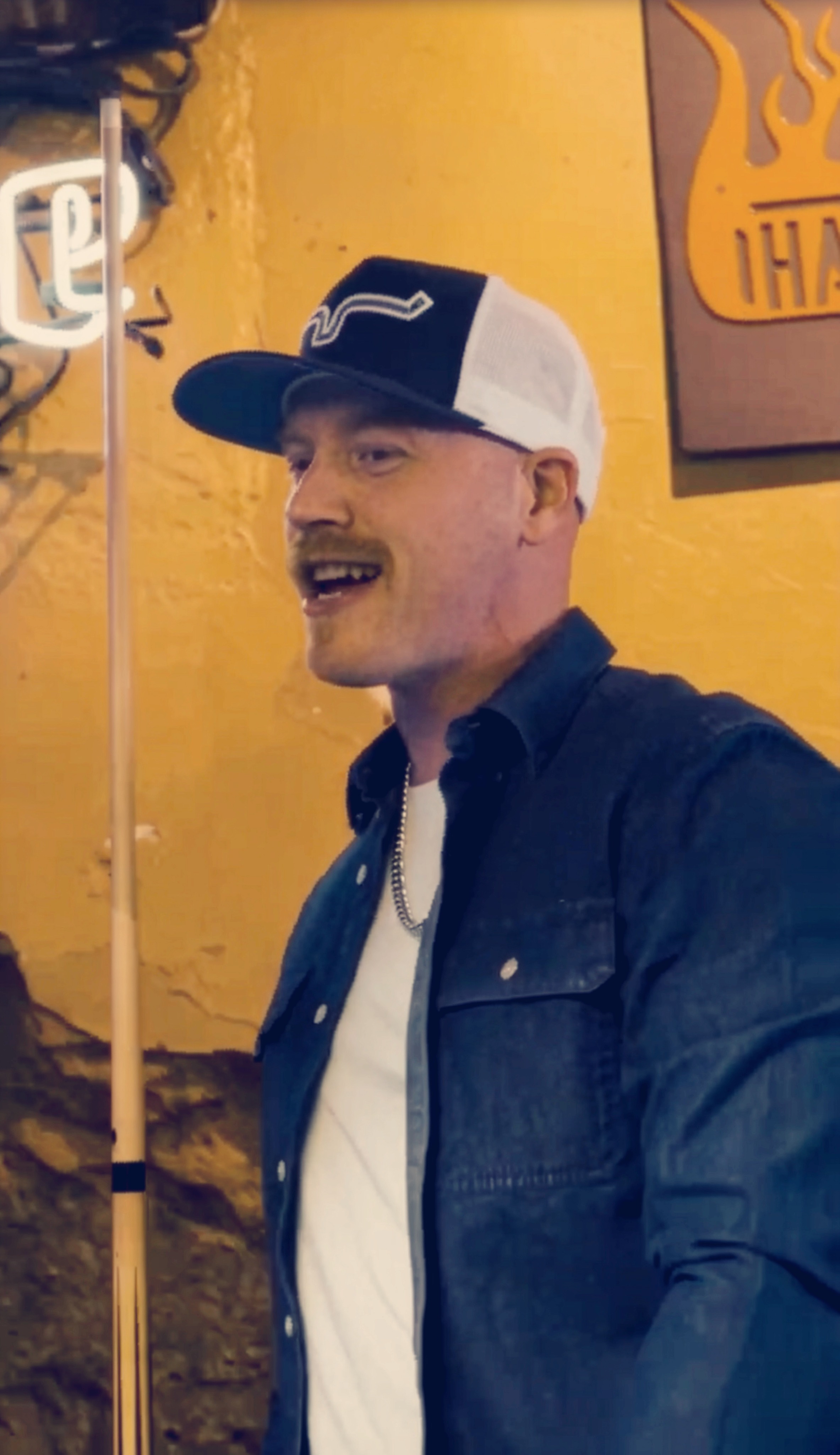Jon Bullard performing under neon in a bar